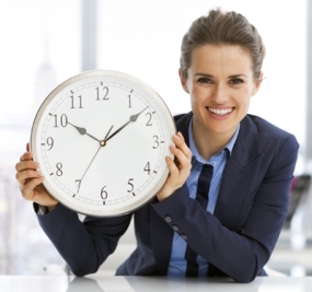 Happy business woman showing clock